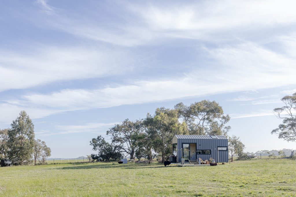 Tiny home on wheels in a rural setting with open sky