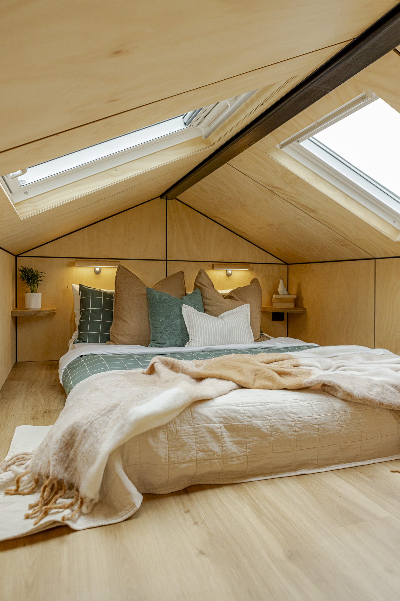 Luxe Loft bedroom with skylights, warm timber finishes and a queen bed