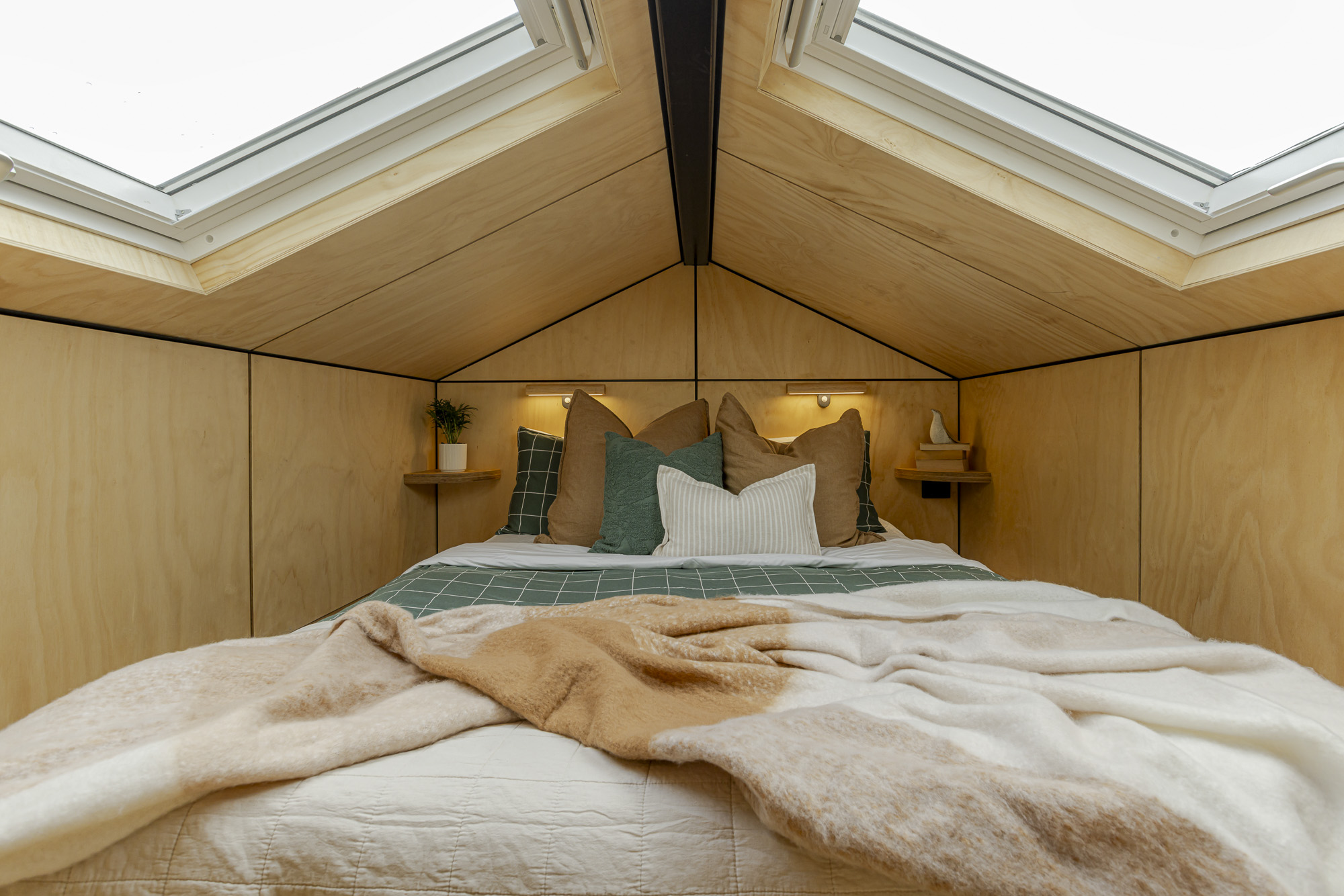 Tiny home on wheels loft bedroom with skylight Loft bedroom with skylight in a tiny home on wheels built for guest accommodation