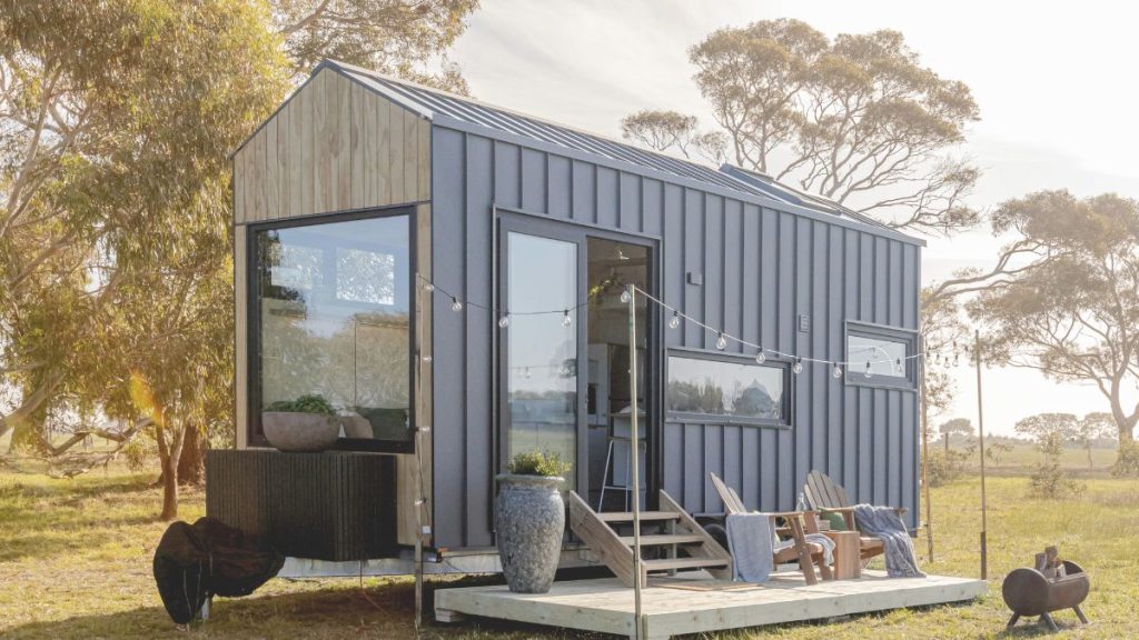 Coastal tiny home on wheels with deck and outdoor seating